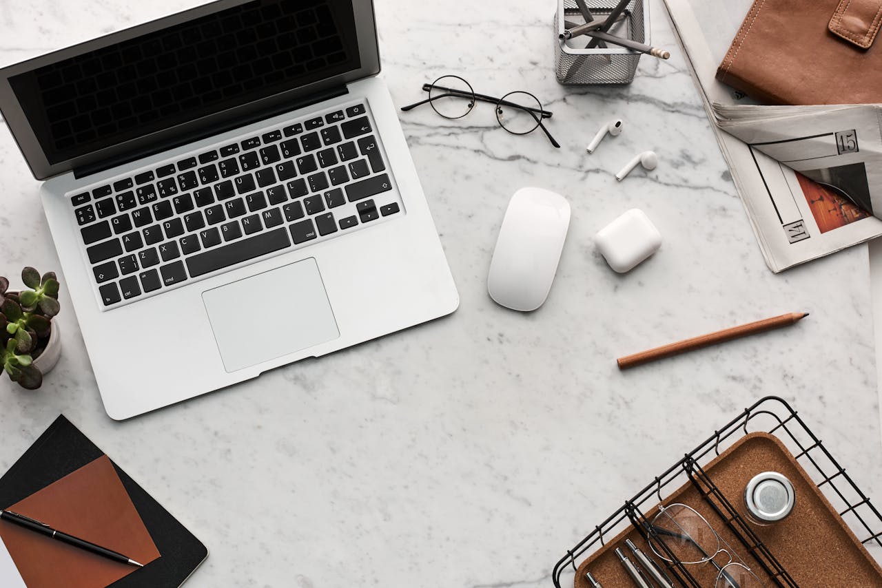 Services-01 Discover a clean, organized workspace featuring a laptop, AirPods, and stationery essentials on a marble desk.